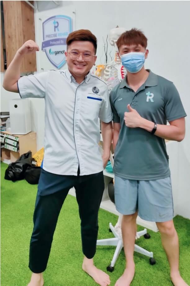 Jaffery and his patient are smiling and posing with a thumbs up in a physical therapy clinic.